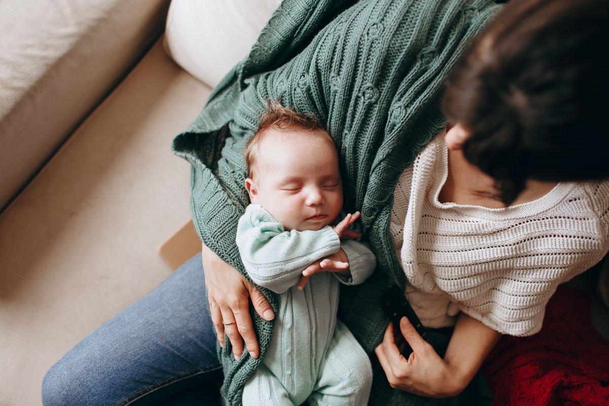 Bébé endormi, enveloppé avec douceur dans les bras de sa maman